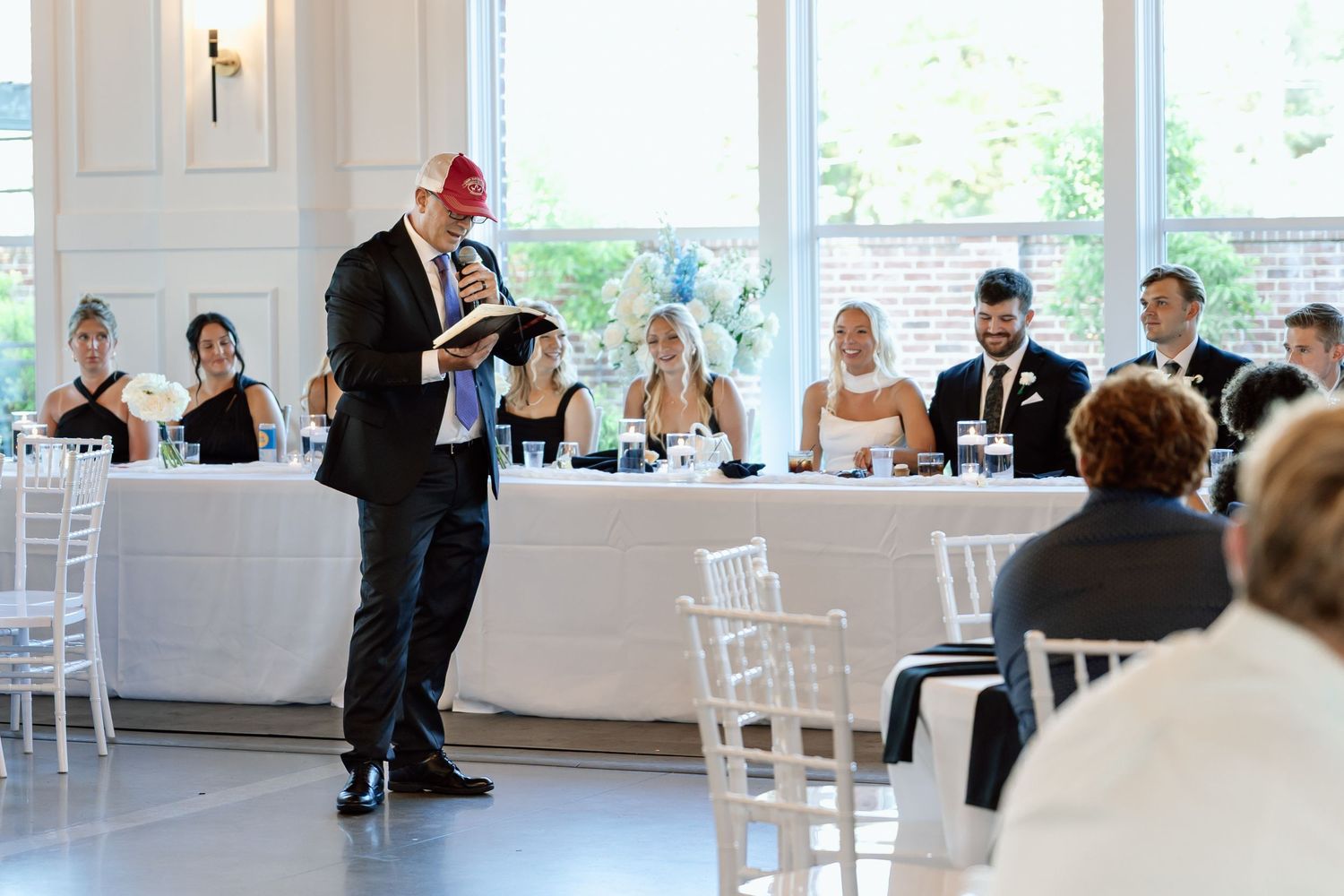 Father of the bride speech at a wedding reception podium while guests listen attentively at The Monroe wedding venue in West Des Moines,