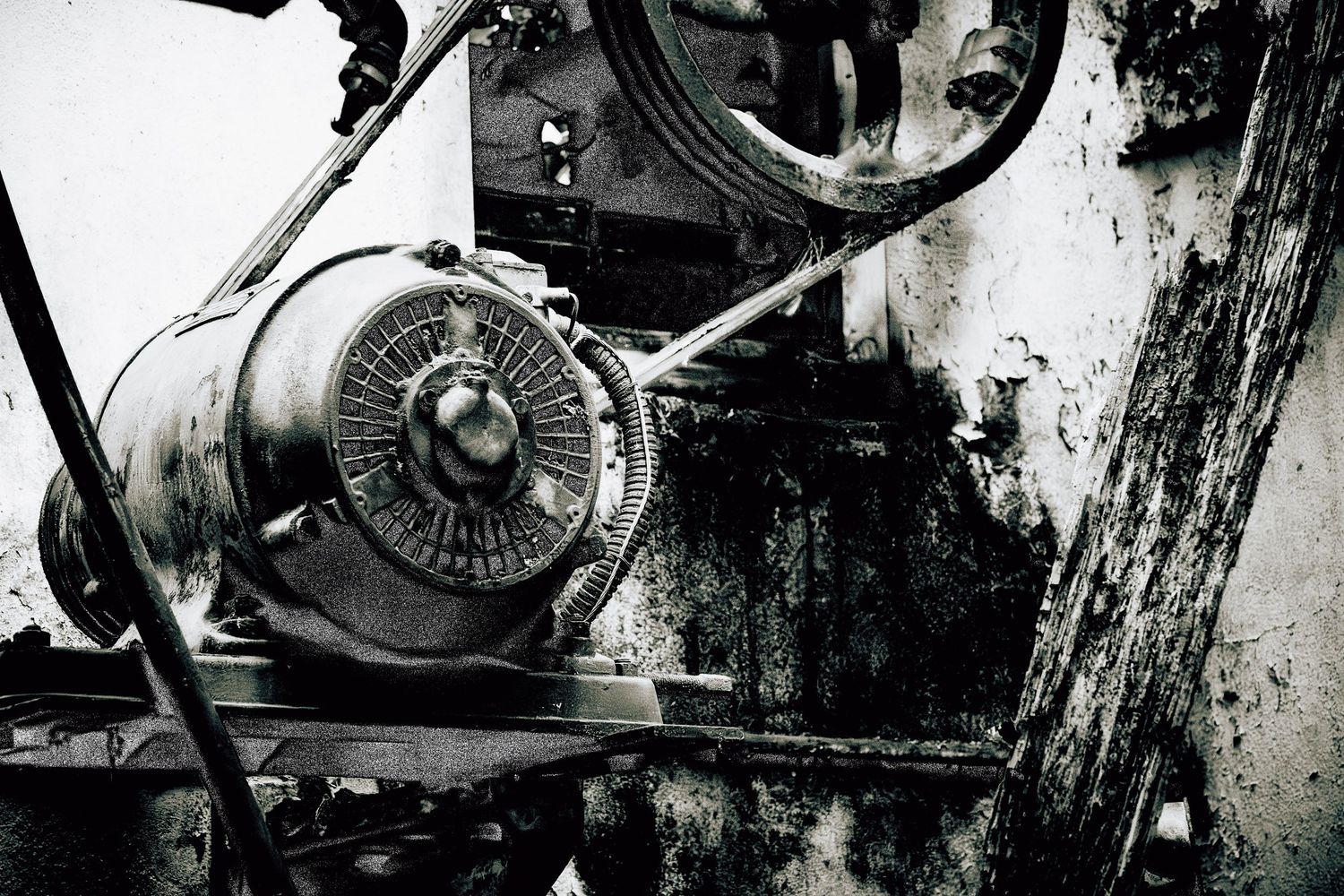 Black and white close-up of industrial machinery with a fan belt and mechanical components.