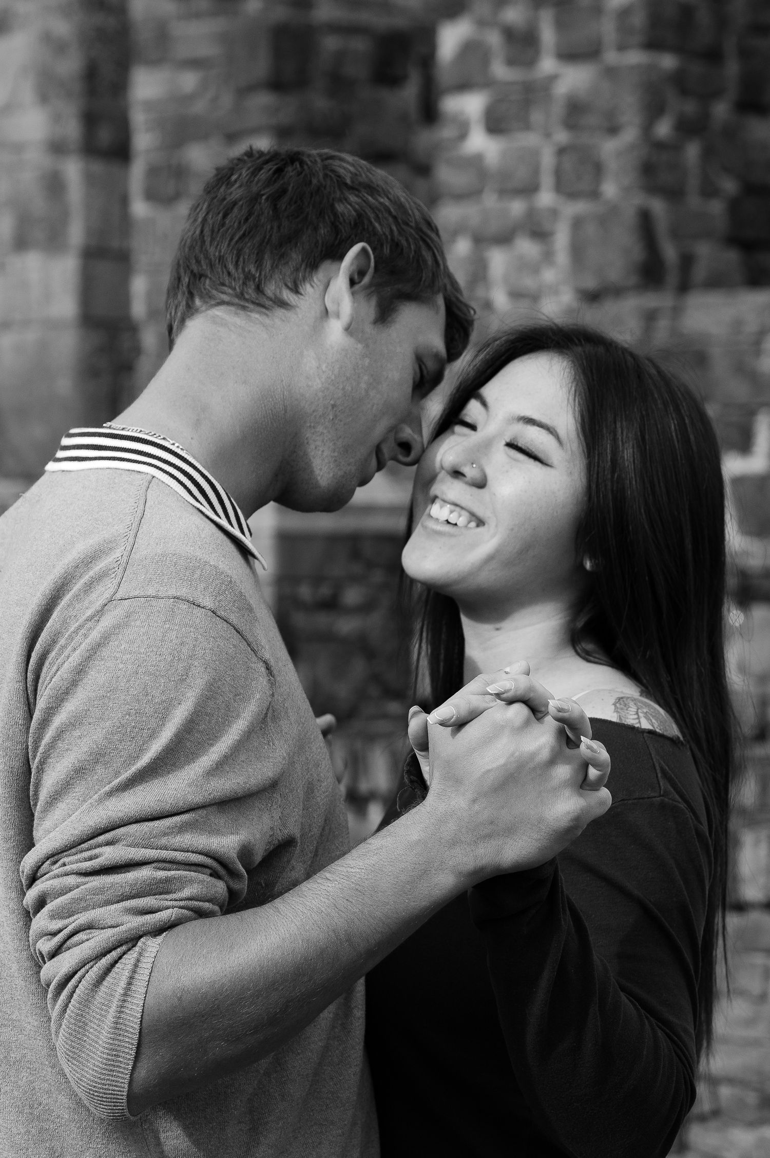 Series of romantic candid moments captured against a stone wall backdrop in Napa Valley winery.