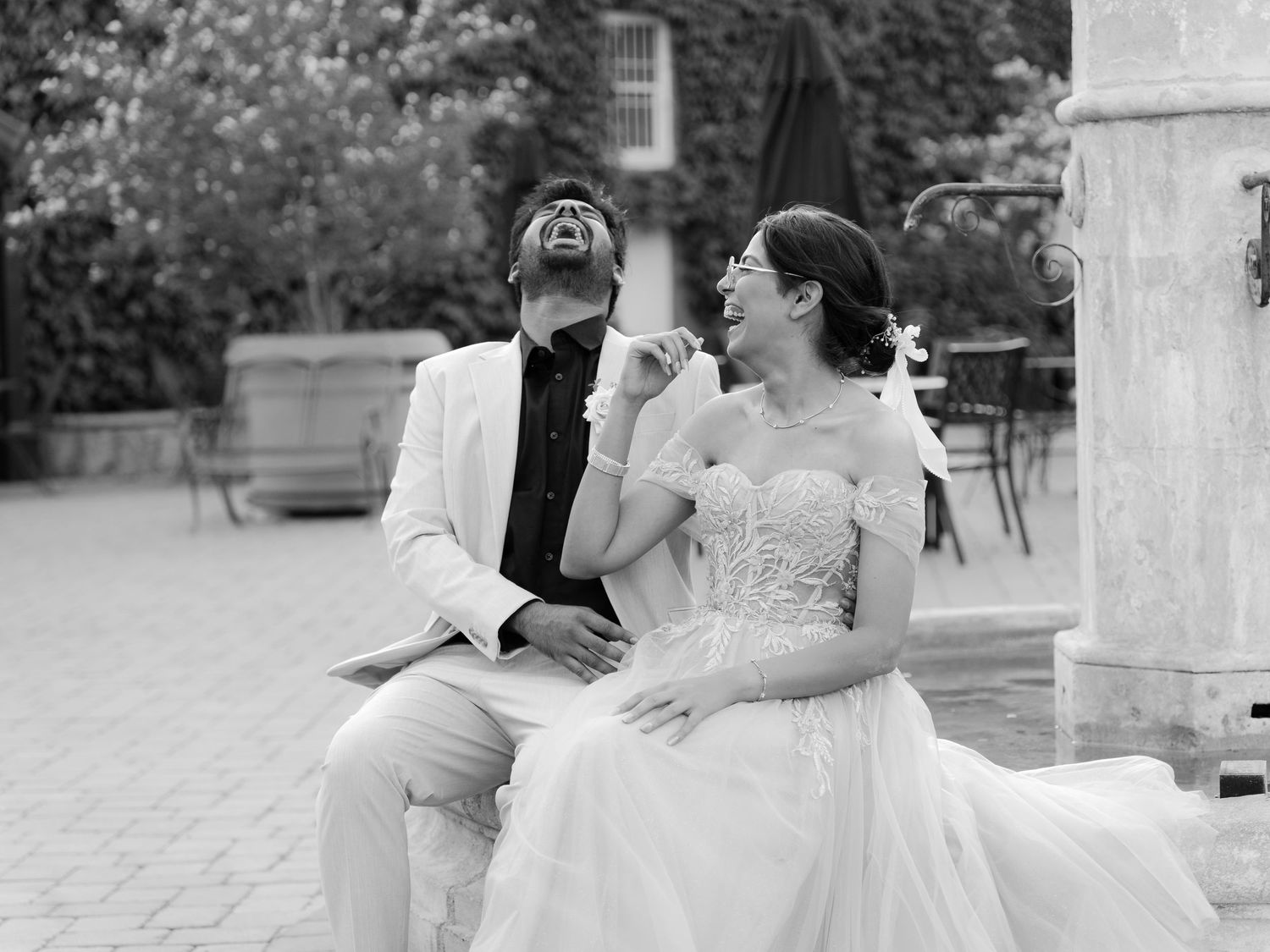 San Jose winery where couple laughing bride and groom sitting together outdoors on their wedding day and engagement  party