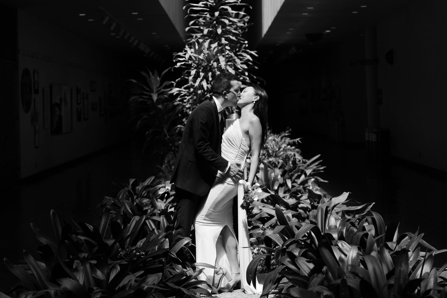 Black and white photo of a couple sharing a romantic kiss at the Marin County civic center for their civil ceremony