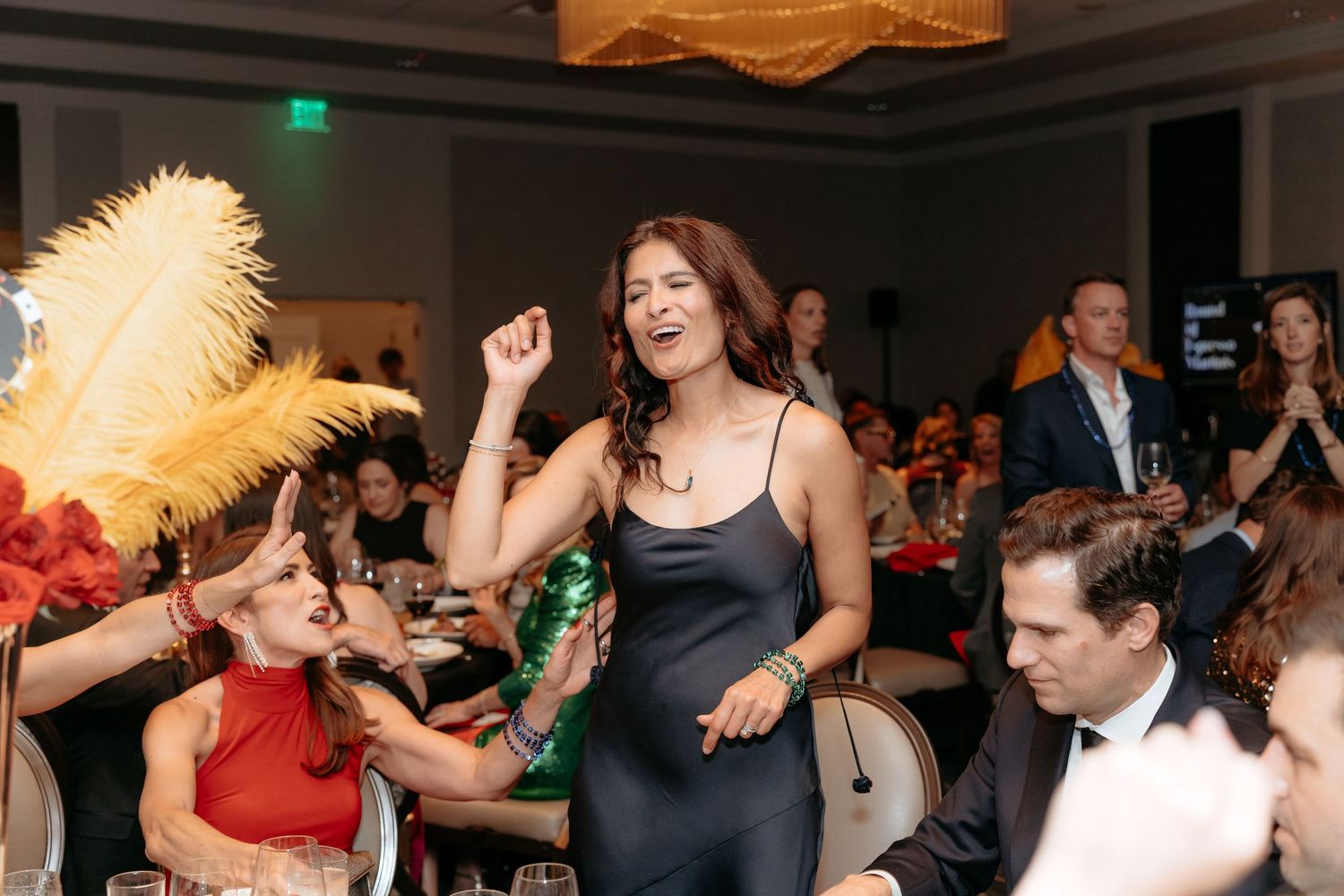 People dancing and celebrating at a lively wedding reception with warm lighting and festive atmosphere.