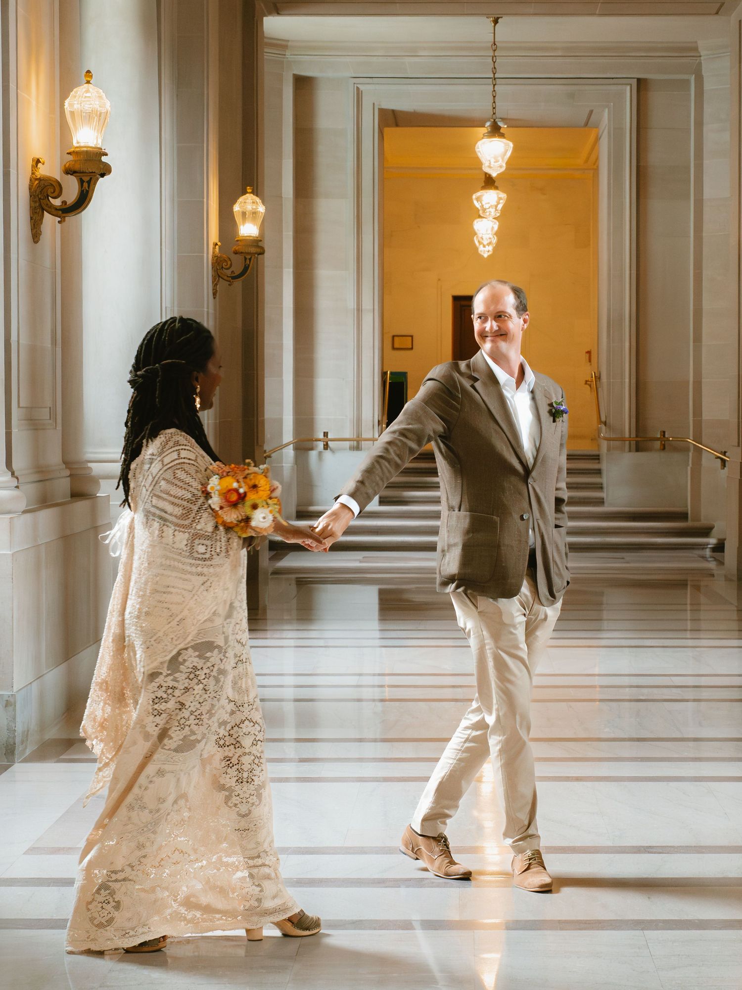 San Francisco Couple holding hands in city hall after their civil ceremony