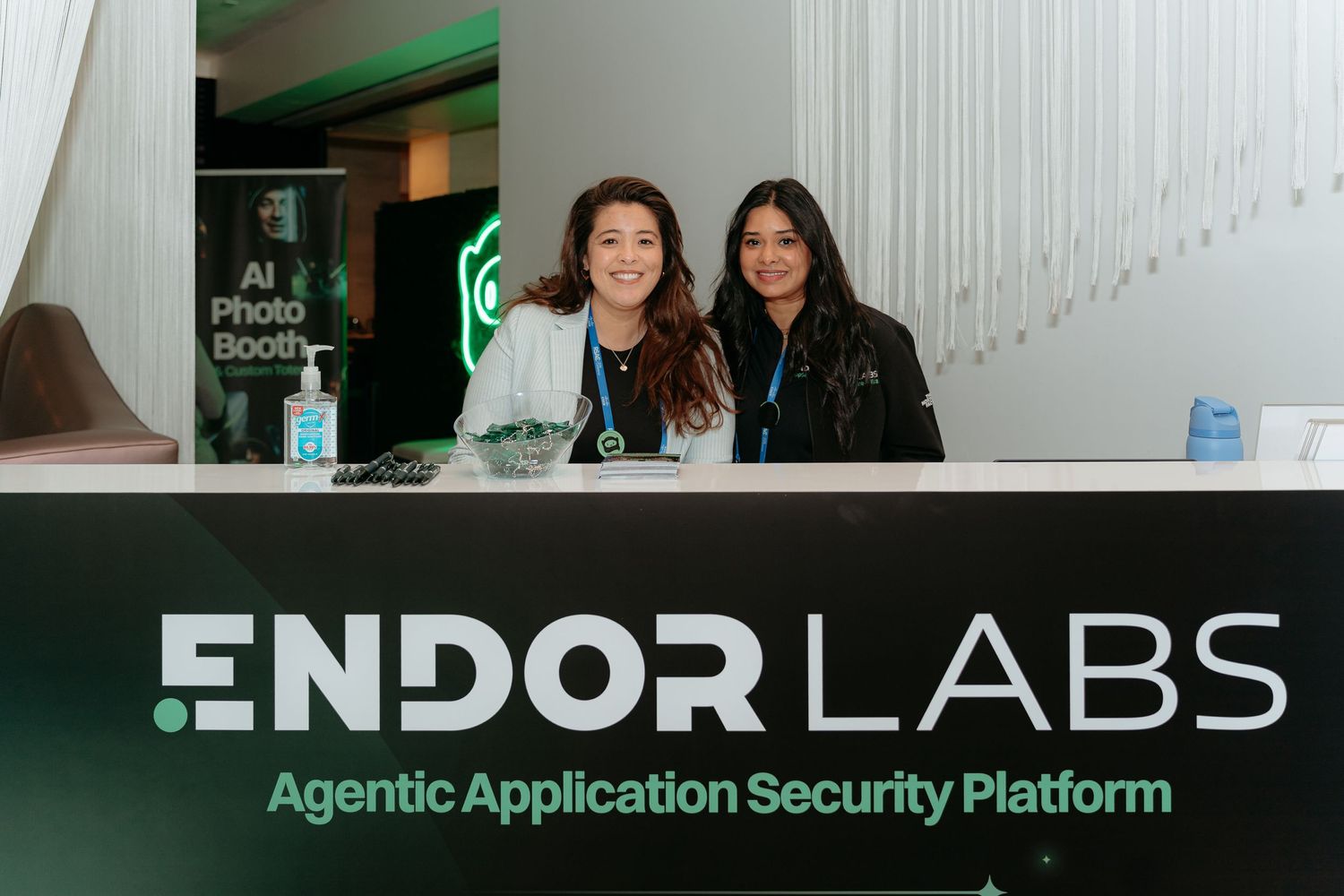 Two women smile at the Endor Labs Agentic Application Security Platform booth at a tech conference.