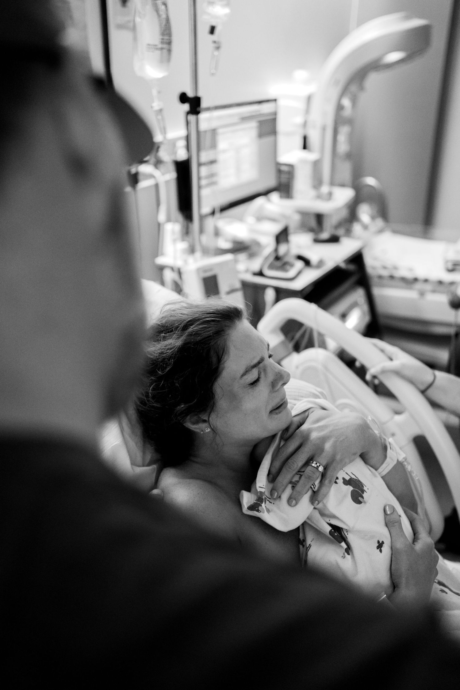 Emotional black and white photo of a new mother holding her newborn for the first time in hospital.