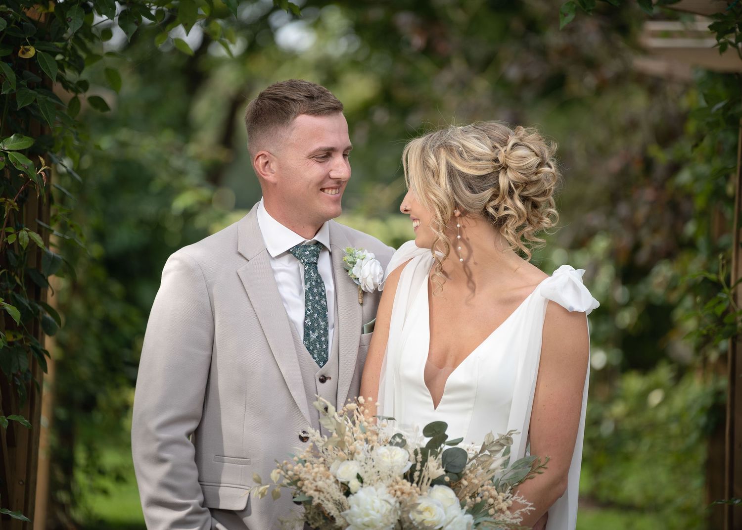 Bride and groom looking at each other while posing together for the camera.