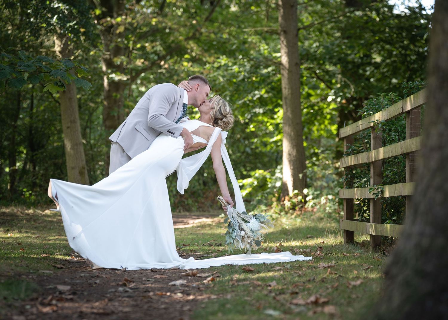 Bride and groom sharing a dipped kiss together.