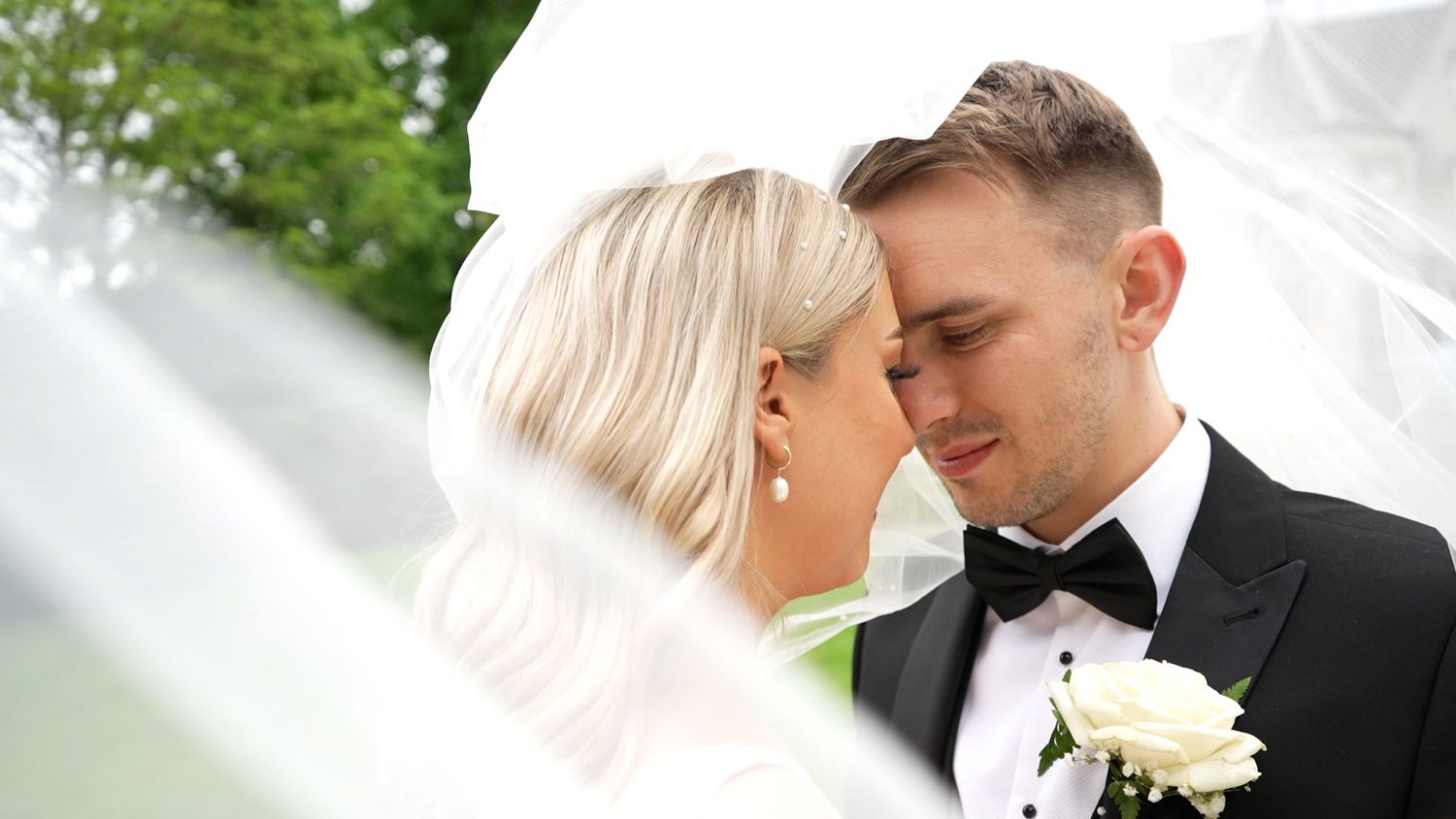 Bride and groom looking at each other while posing together for the camera.