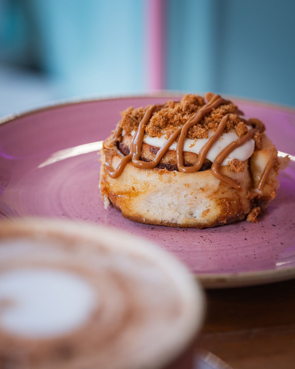 Close-up of a cinnamon roll in a pink cup at cinnammmm cafe