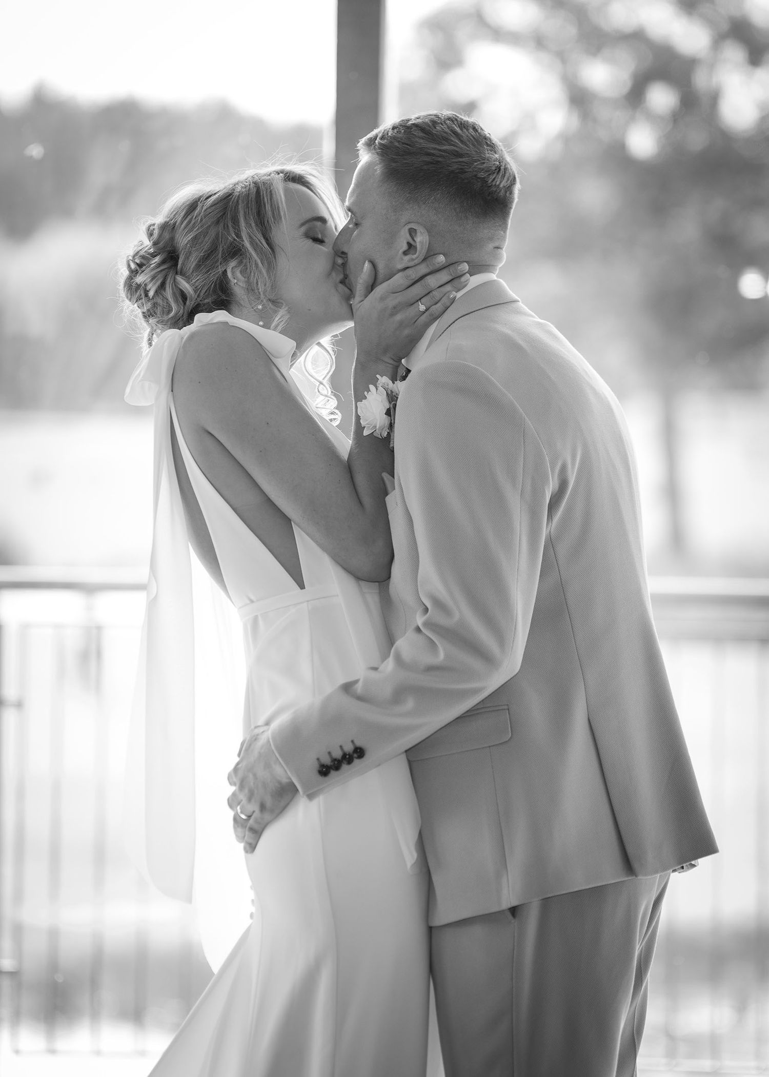 Bride and groom first kiss in black & white