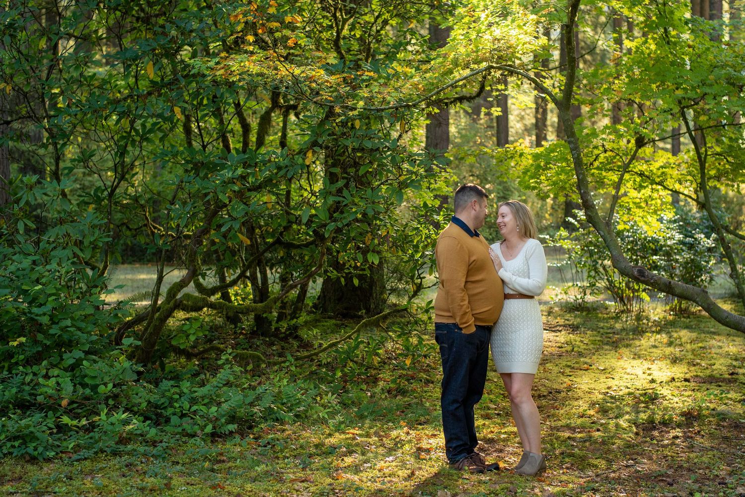 Couple sharing intimate moment in lush green forest garden setting.