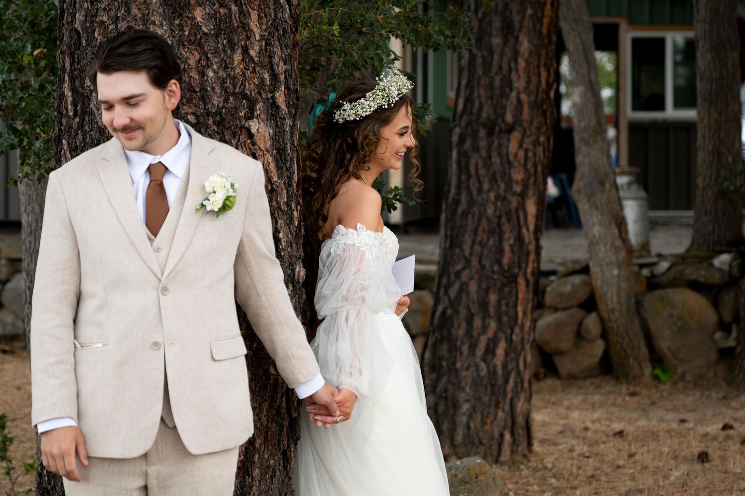 Bride and groom hold hands next to a tree during the first touch at their oregon wedding