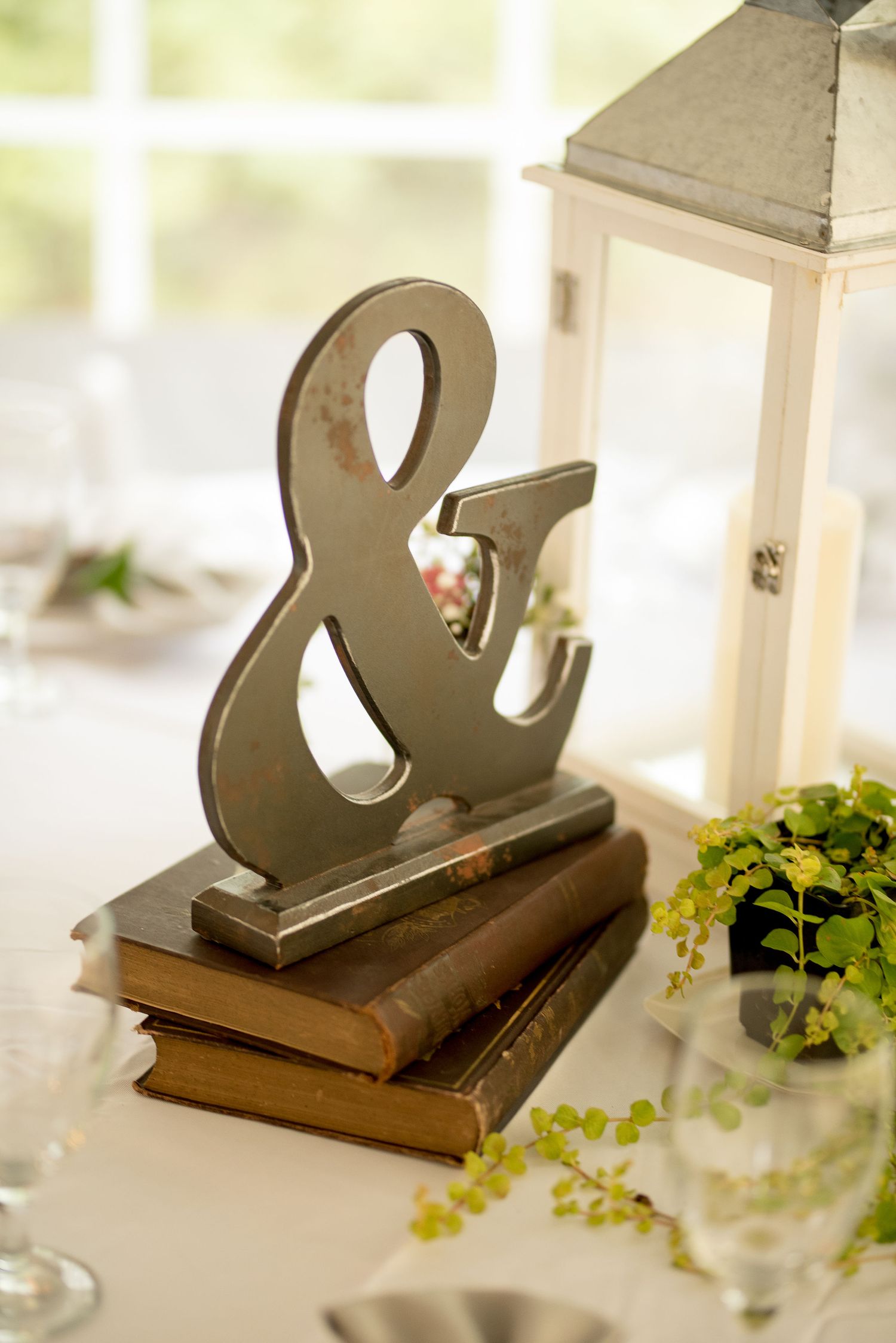 Decorative ampersand symbol on vintage books as wedding table decor.