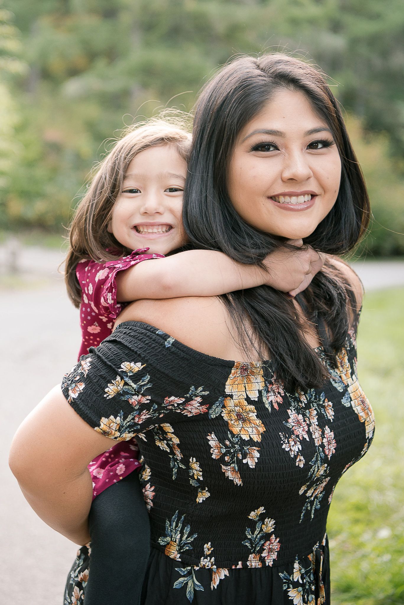 A floral dress stands out against a natural outdoor backdrop during a family photo session.