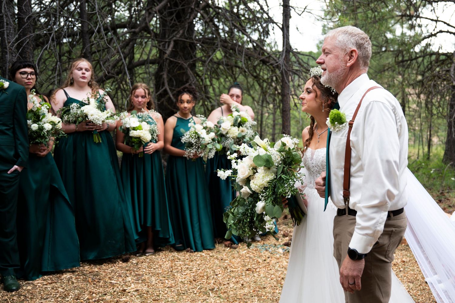 A bride's father prepares to give her away as bridesmaids look on during an oregon wedding ceremony
