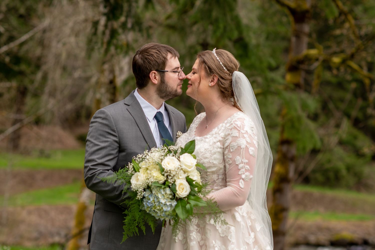 Romantic wedding portraits in a natural outdoor setting with white floral bouquet.