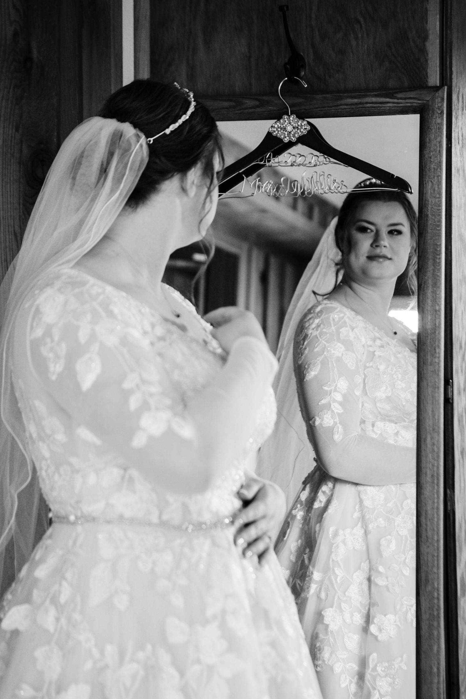 Wedding dress details show delicate lace and fabric hanging in preparation.