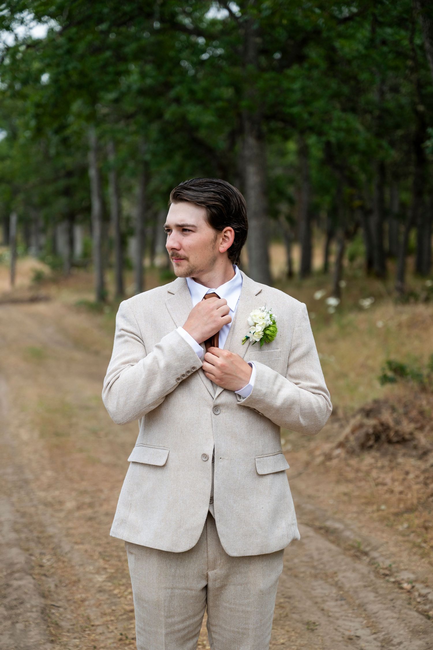 A groom straightens his tie in The Dalles, Oregon