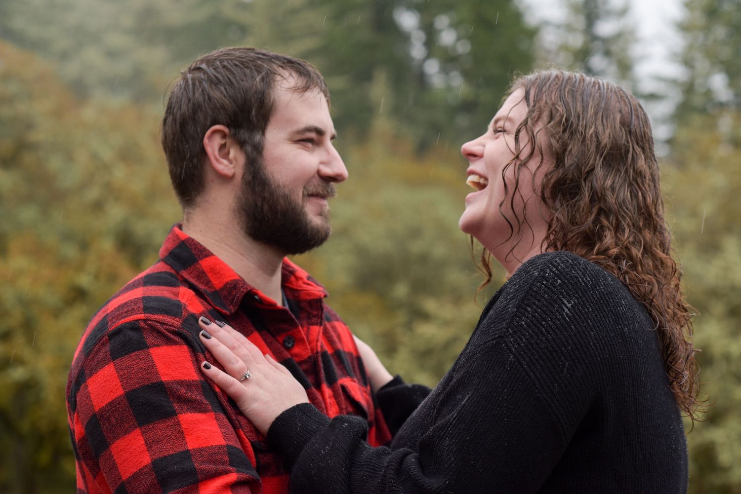 A couple shares candid laughing moments together during an outdoor photo session.