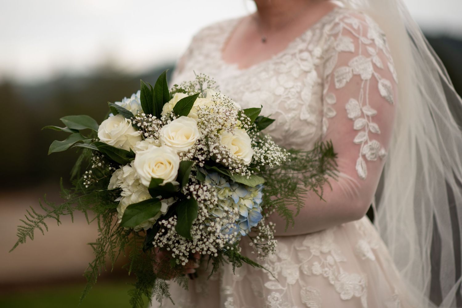 Elegant white wedding bouquet with lace details and delicate florals.