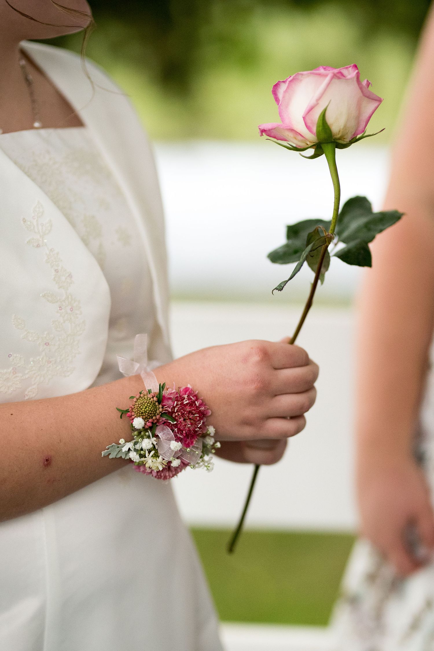 Pink roses and delicate corsages worn by wedding attendants.