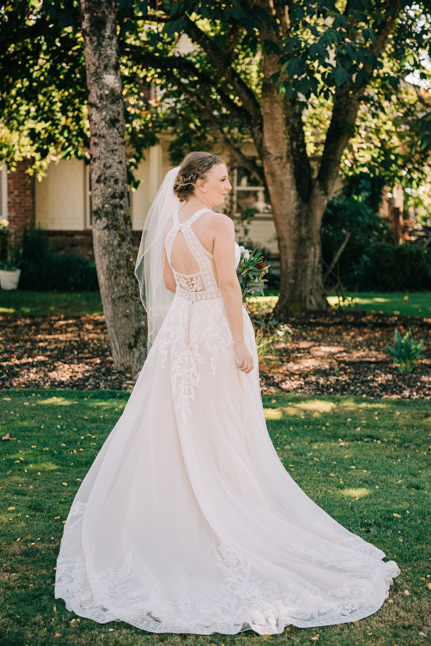 Detailed shots of a lace wedding dress train flowing across green grass.