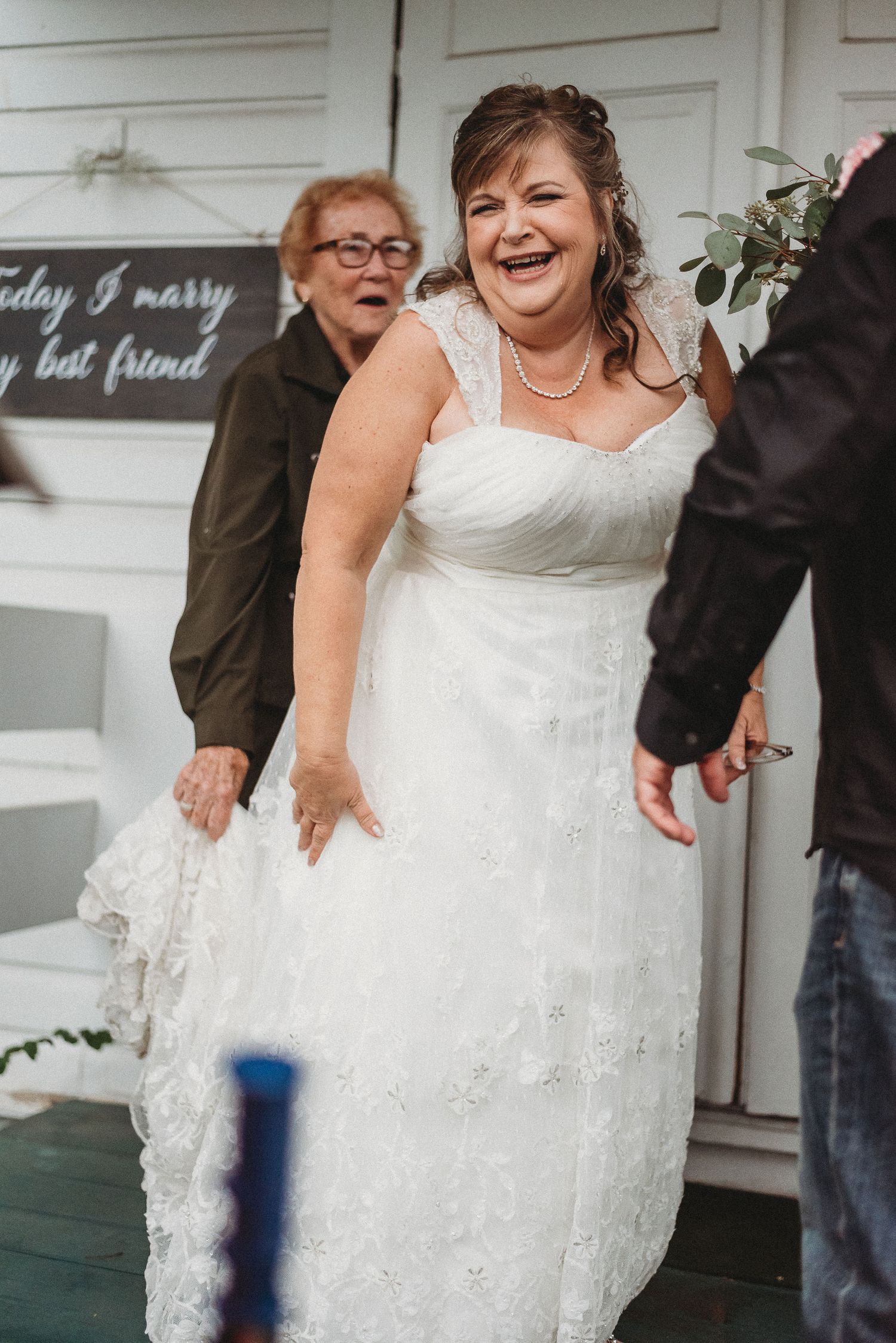 A joyful moment captured at a wedding entrance with a white lace dress.