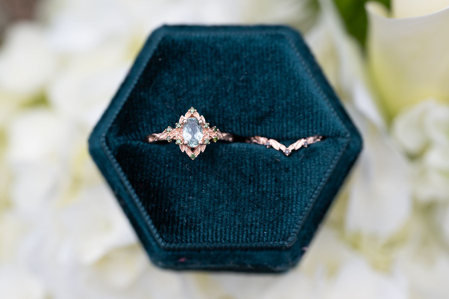 Detail photo of an oregon bride's engagement and wedding rings in a green ring ring holder