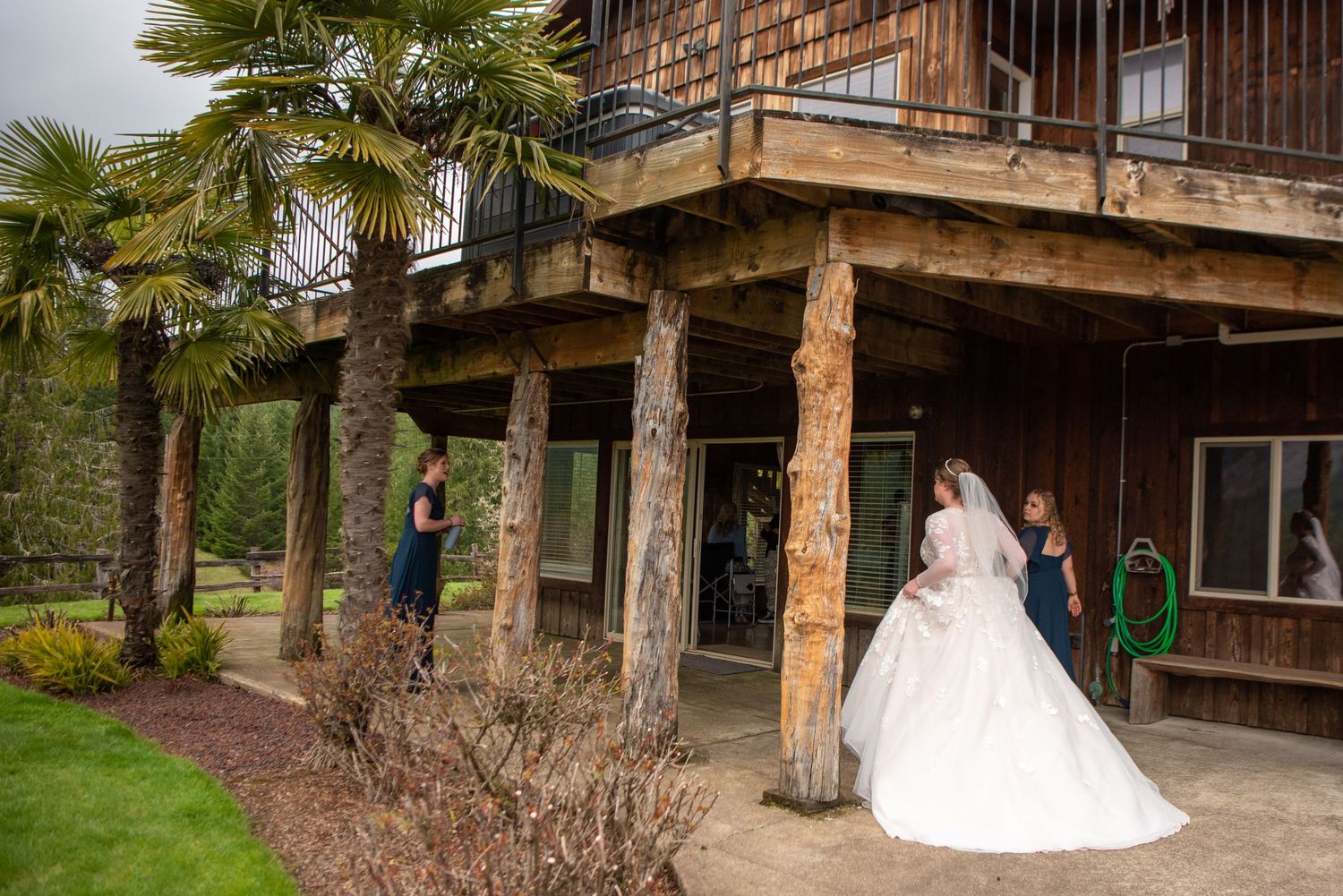 Rustic wooden venue exterior with palm trees and natural landscaping.