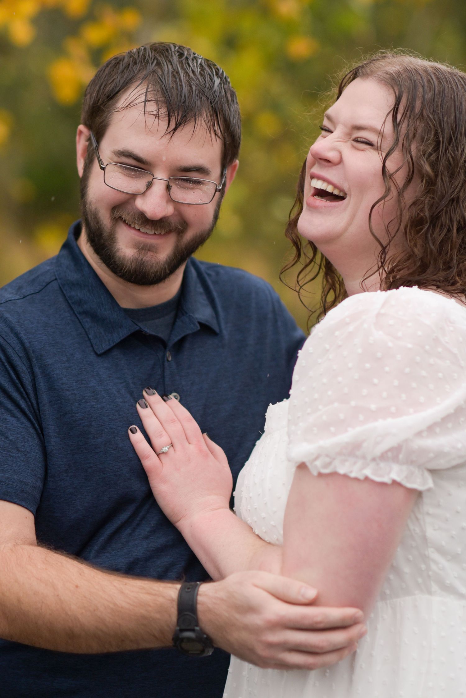 A couple shares genuine laughter during an intimate outdoor photo session.