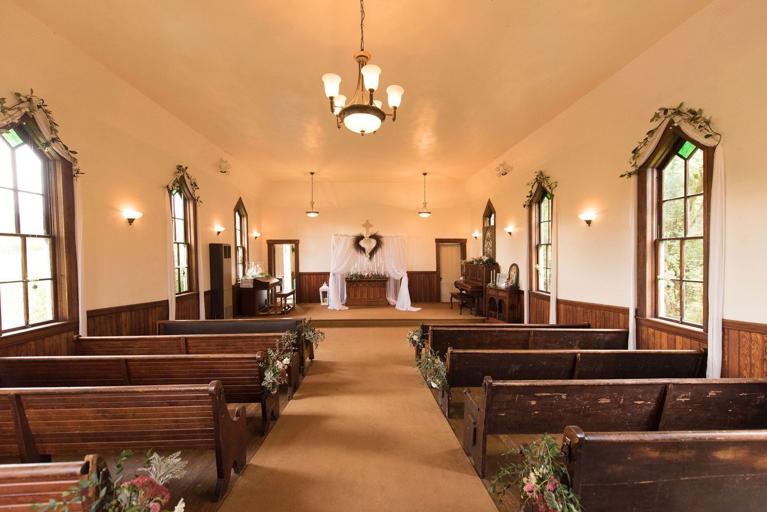 Interior of a traditional chapel with wooden pews and vaulted ceiling.