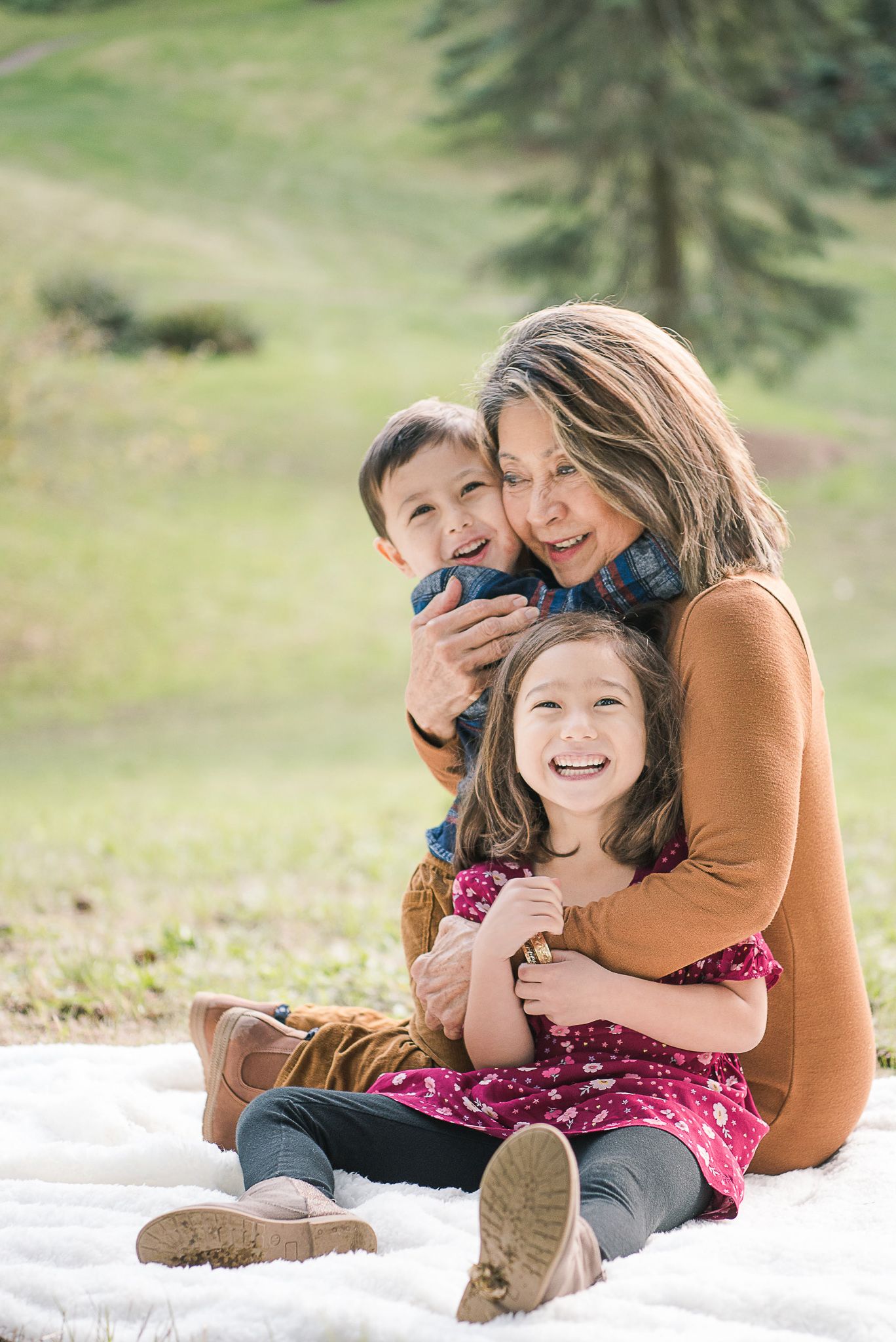 A cozy family moment captured on a white blanket outdoors during autumn.