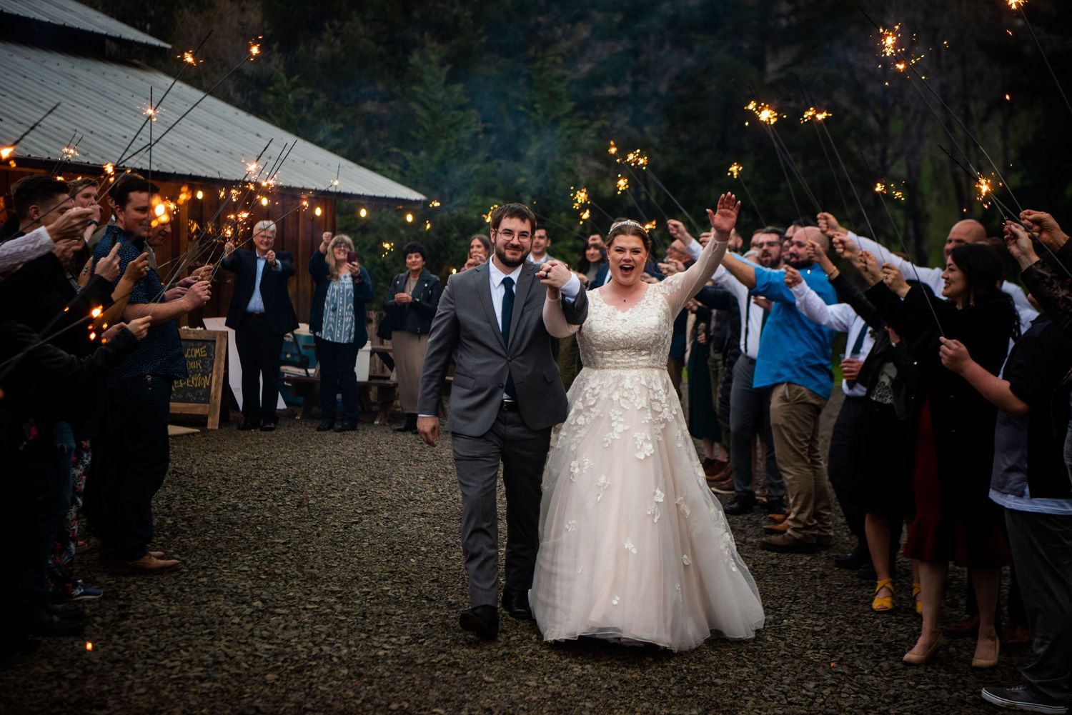 Evening wedding reception with string lights creating a magical atmosphere outdoors.