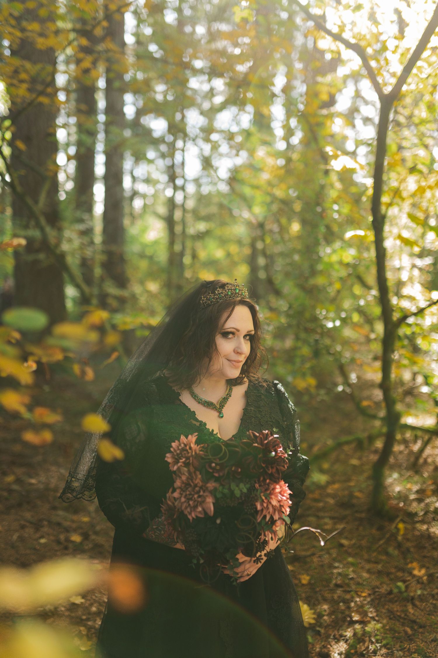Ethereal woodland photography series with dramatic black veil and floral accents against autumn forest backdrop.