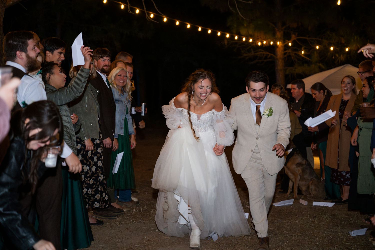 Bride and groom duck below paper airplanes during their special oregon wedding exit