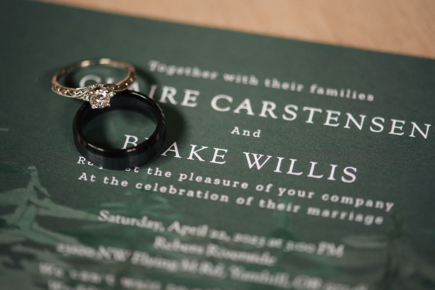 Wedding invitation details printed in elegant typography on dark paper.