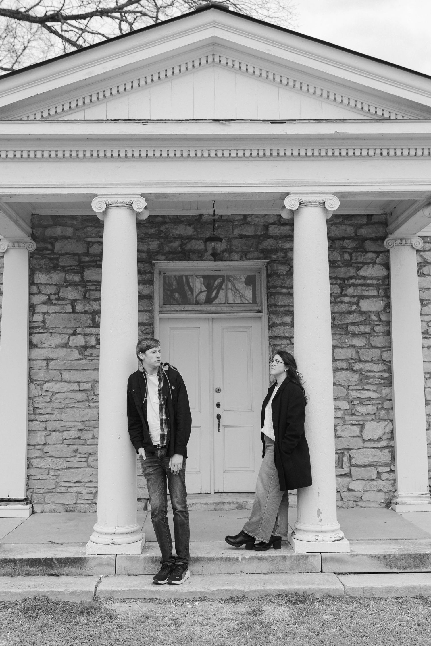 Series of artistic black and white portraits in front of a classic stone building with white columns in Nashville.