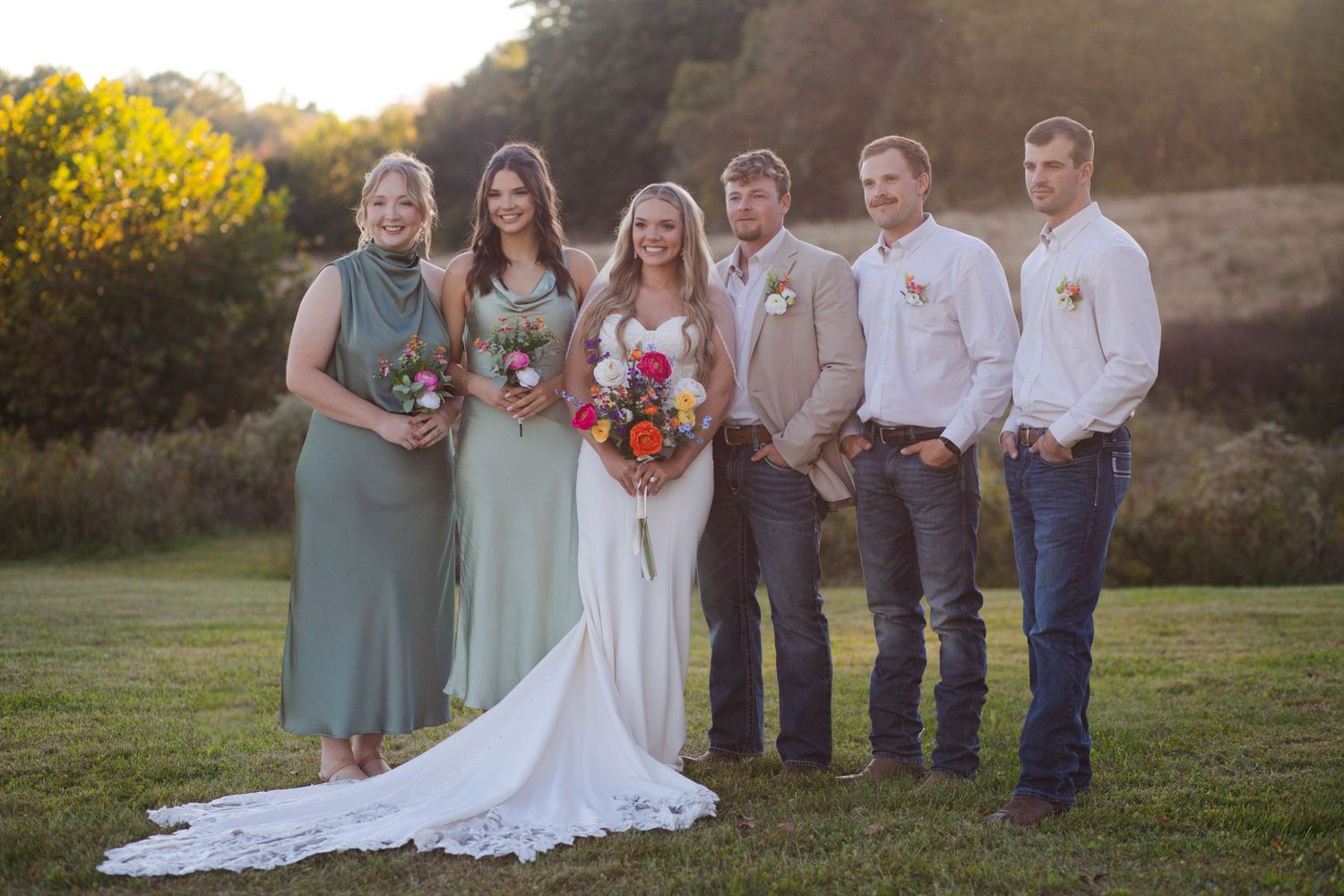 Nashville micro wedding party poses outdoors at golden hour, bridesmaids in sage green dresses with colorful bouquets.