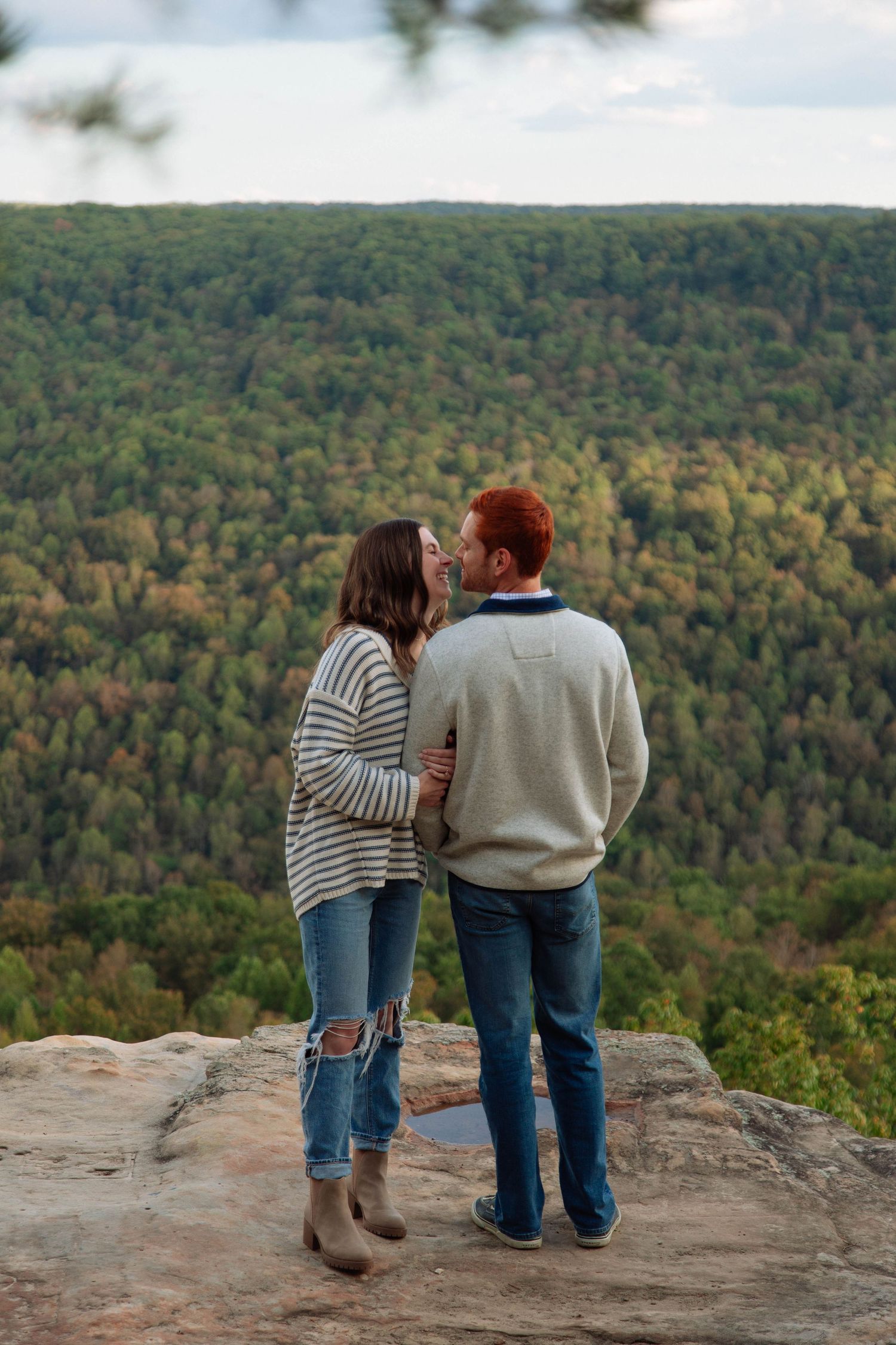 Couple stands on rocky overlook admiring scenic mountain vista during fall season in Nashville.