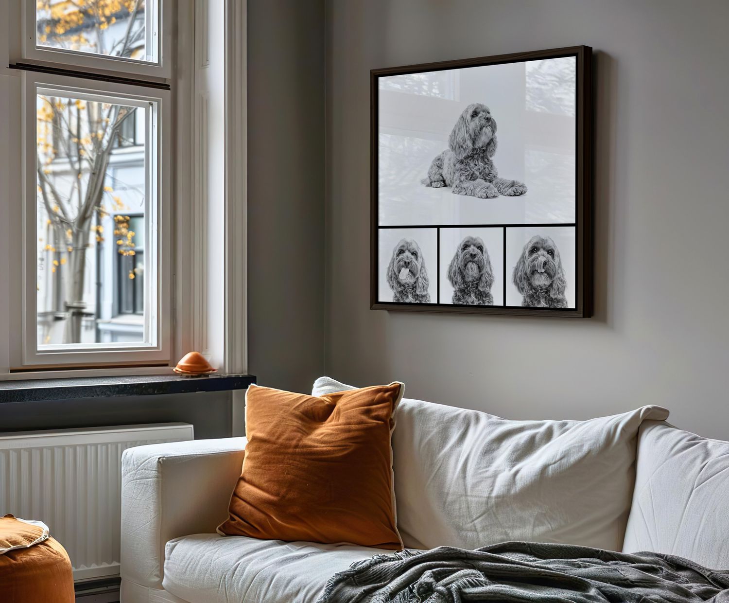 Framed black and white dog portrait collage hanging above a white sofa in a cozy living room.