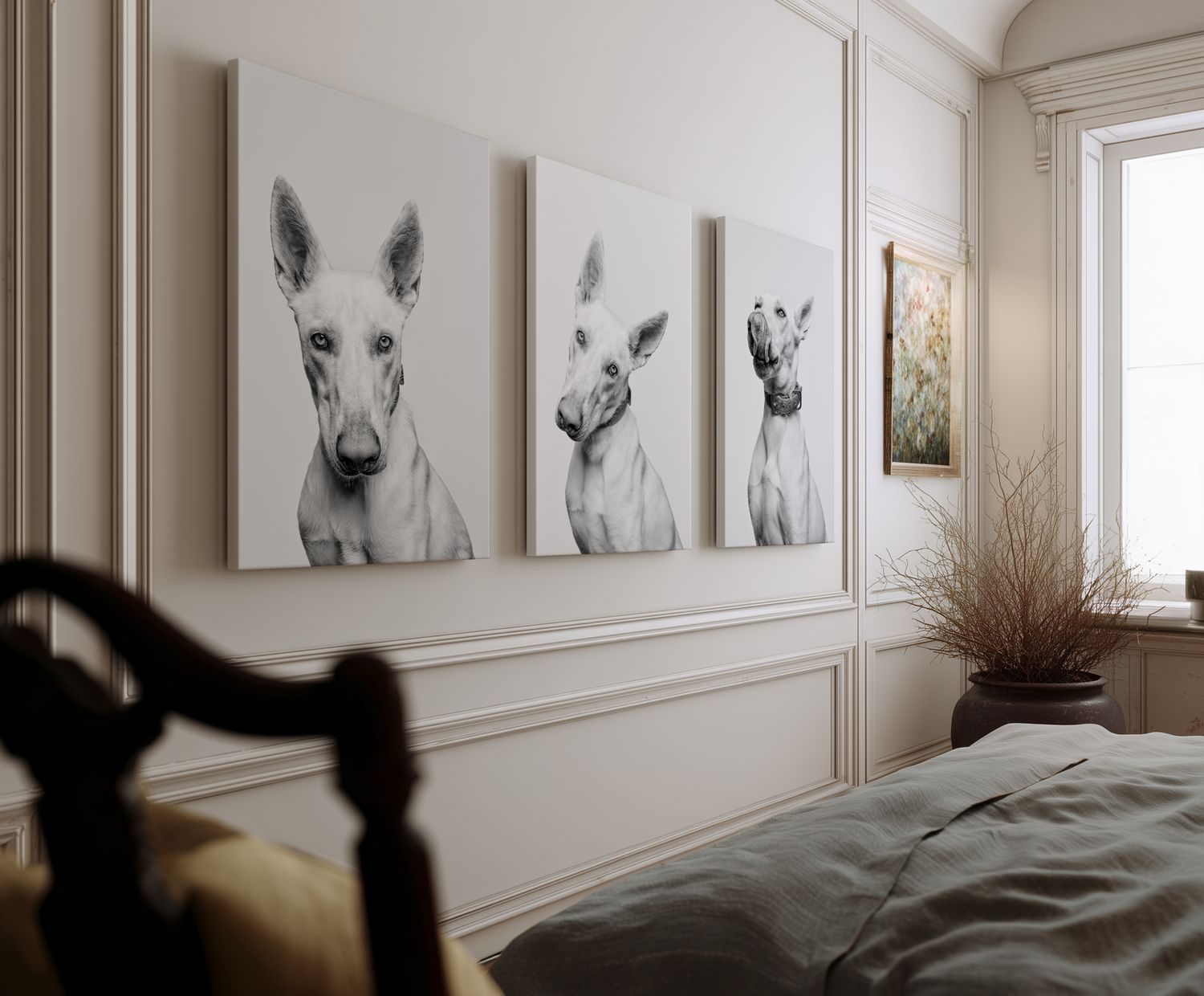 Three black and white animal portrait canvases displayed in a row on a white paneled wall above a bed.