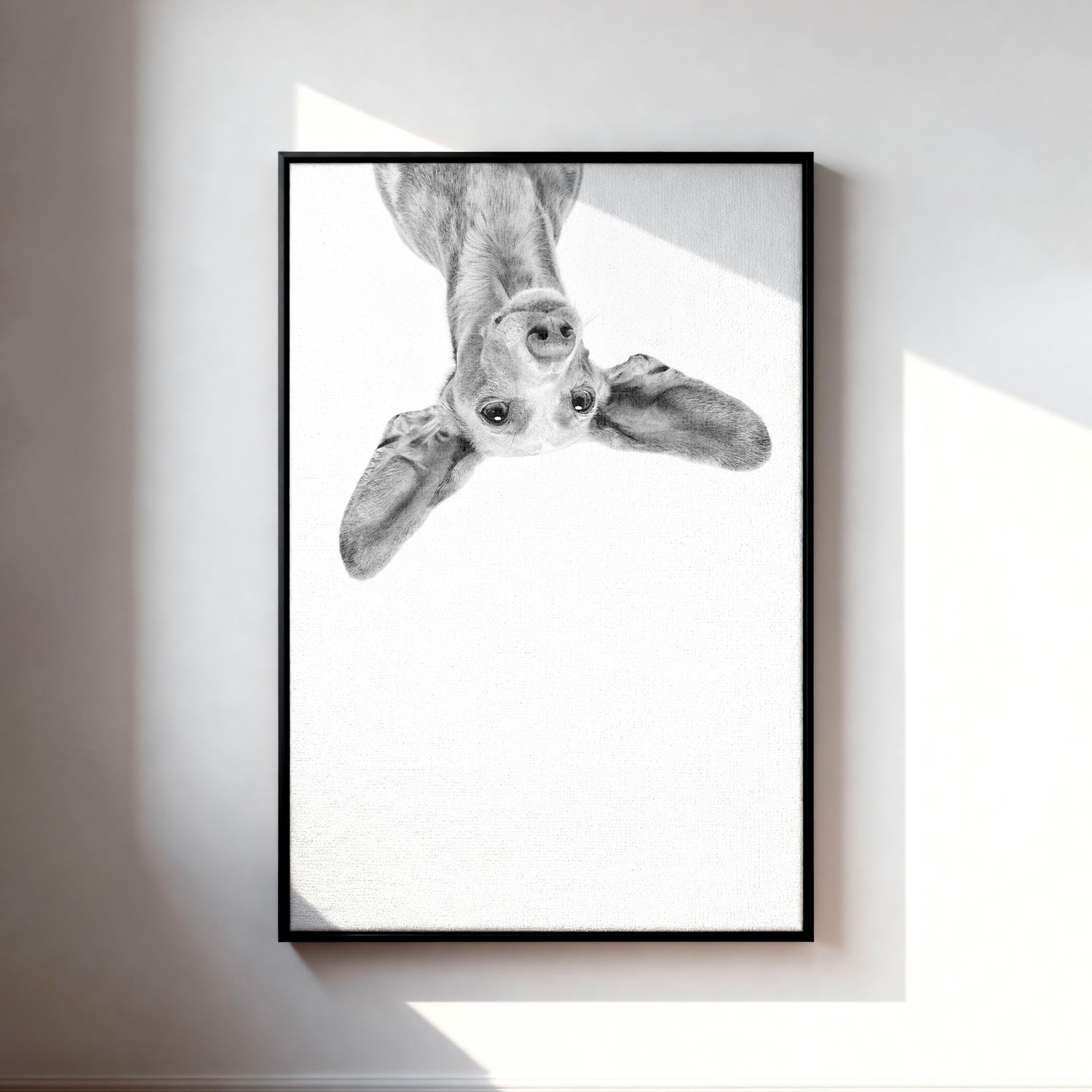 Black and white art print of a curious dog peering downward, framed in black, displayed on a white wall.