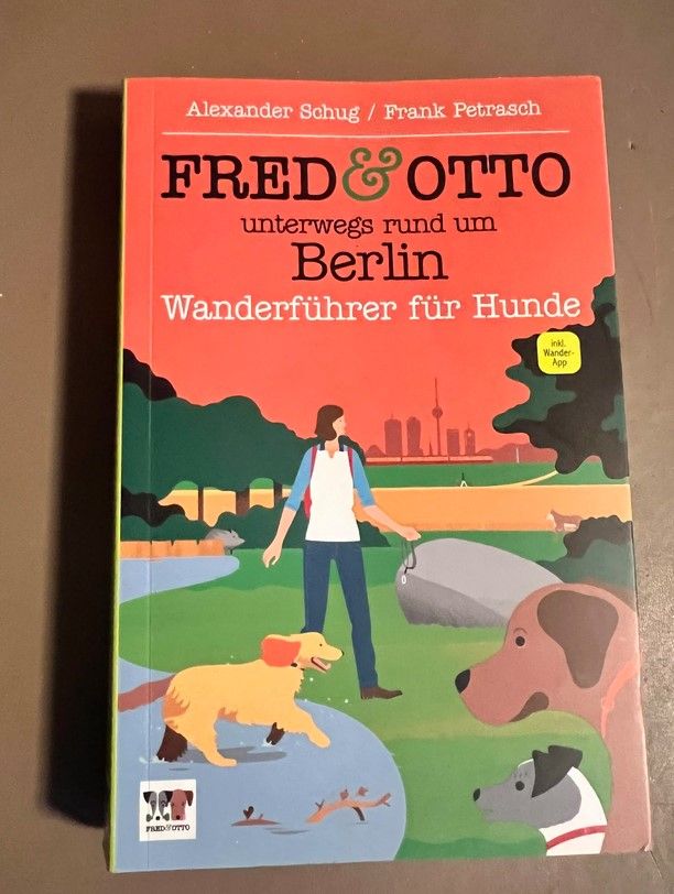 Fred and Otto Berlin dog hiking guide book cover featuring illustrated dogs and owner in a park.