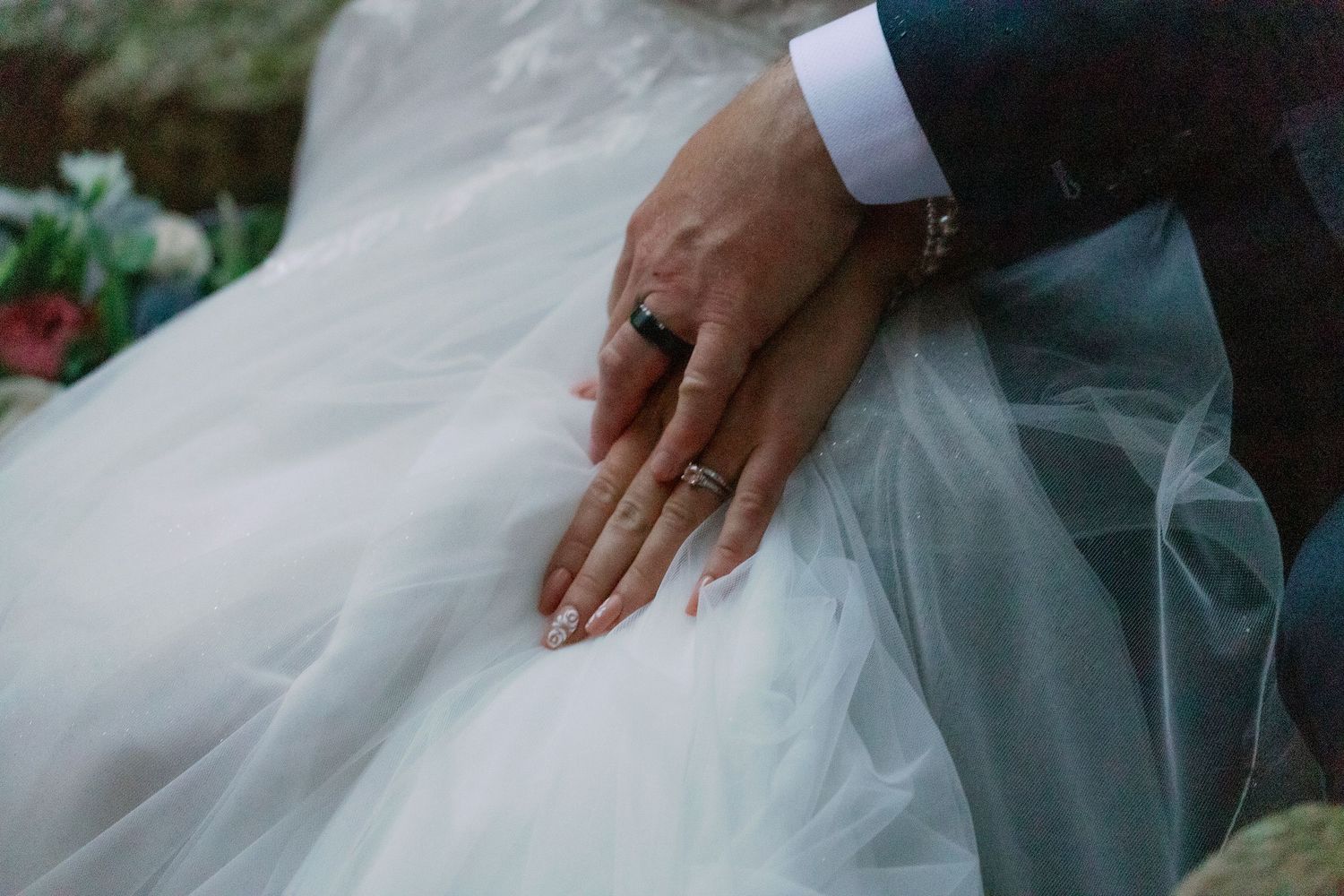 bride and groom hold hands and show off rings