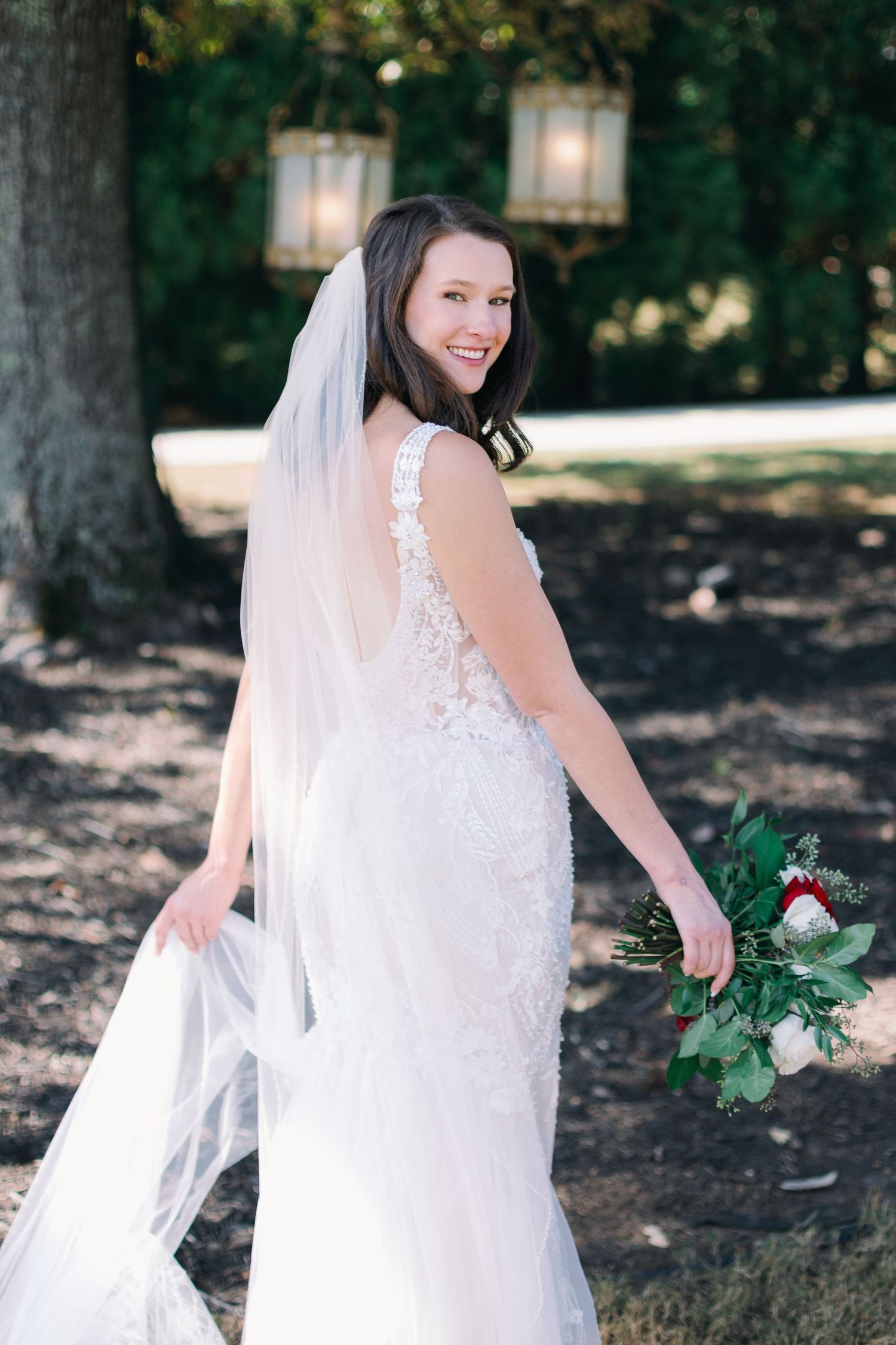 bride turns and hold dress for bridal portraits