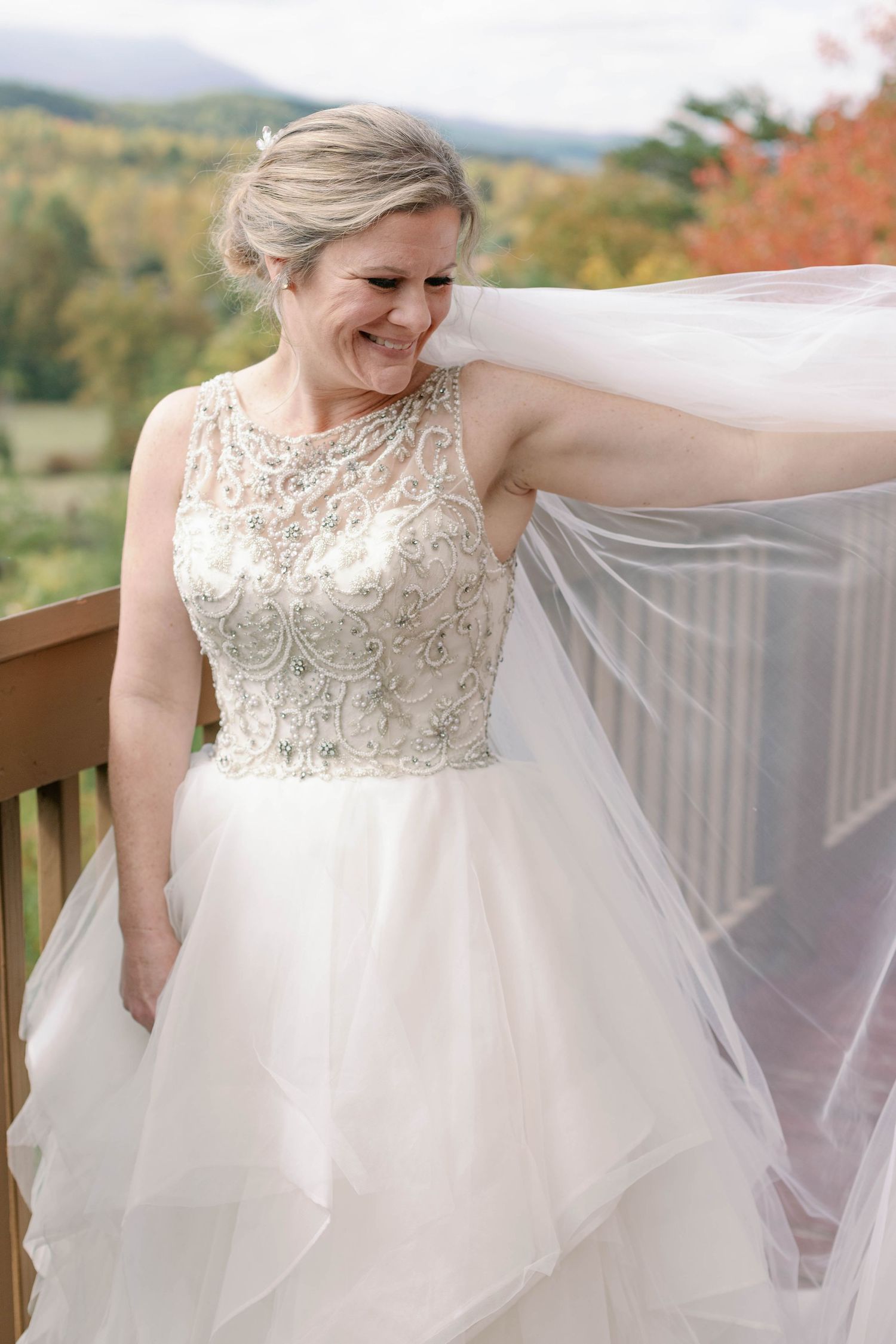 bride smiles and looks at her veil playfully