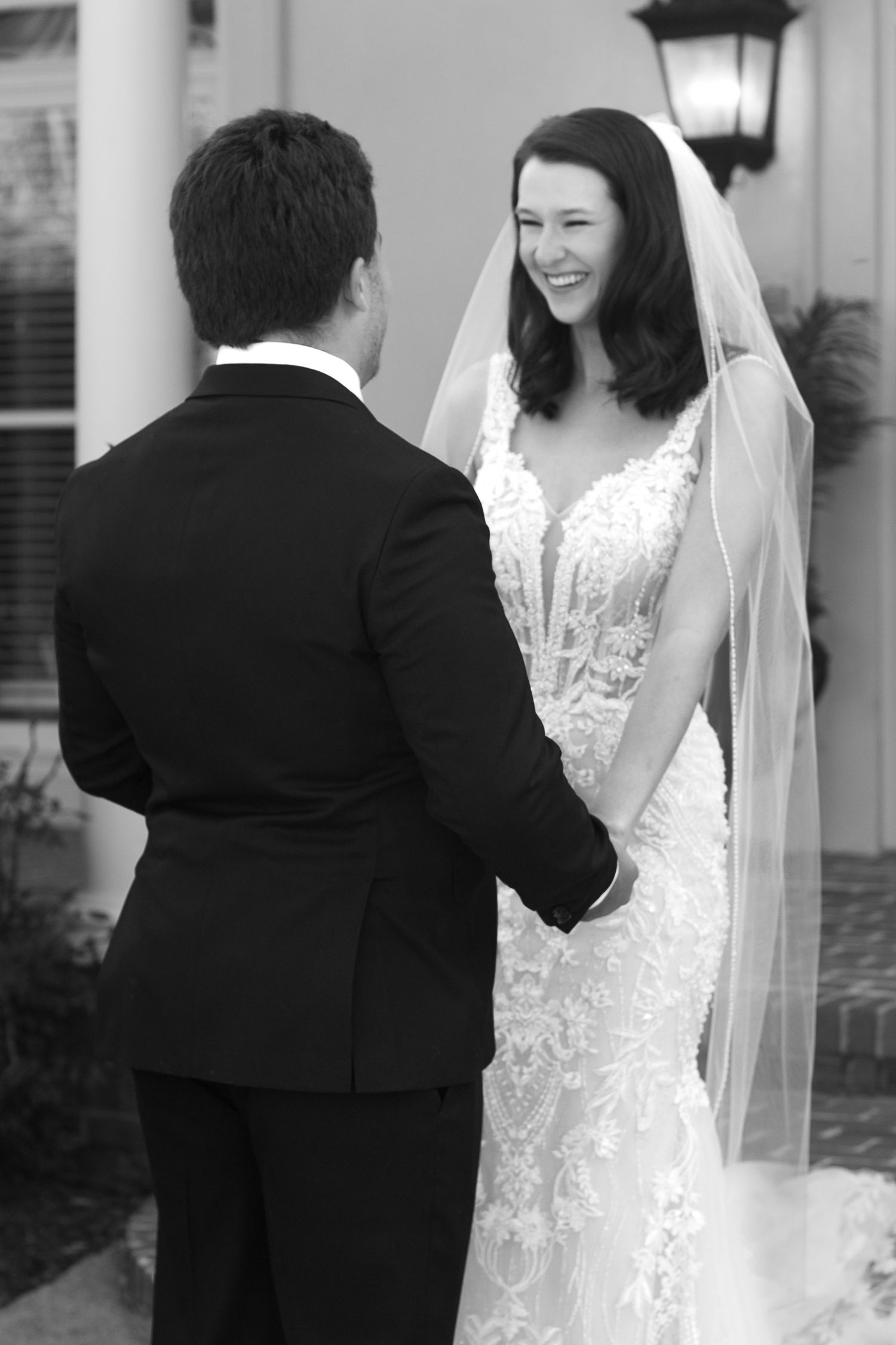 black and white photo of bride and groom look at each other and smile