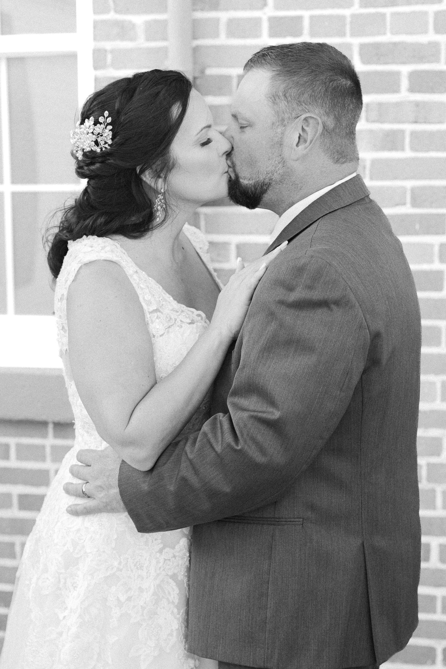 bride and groom kiss in black and white photo