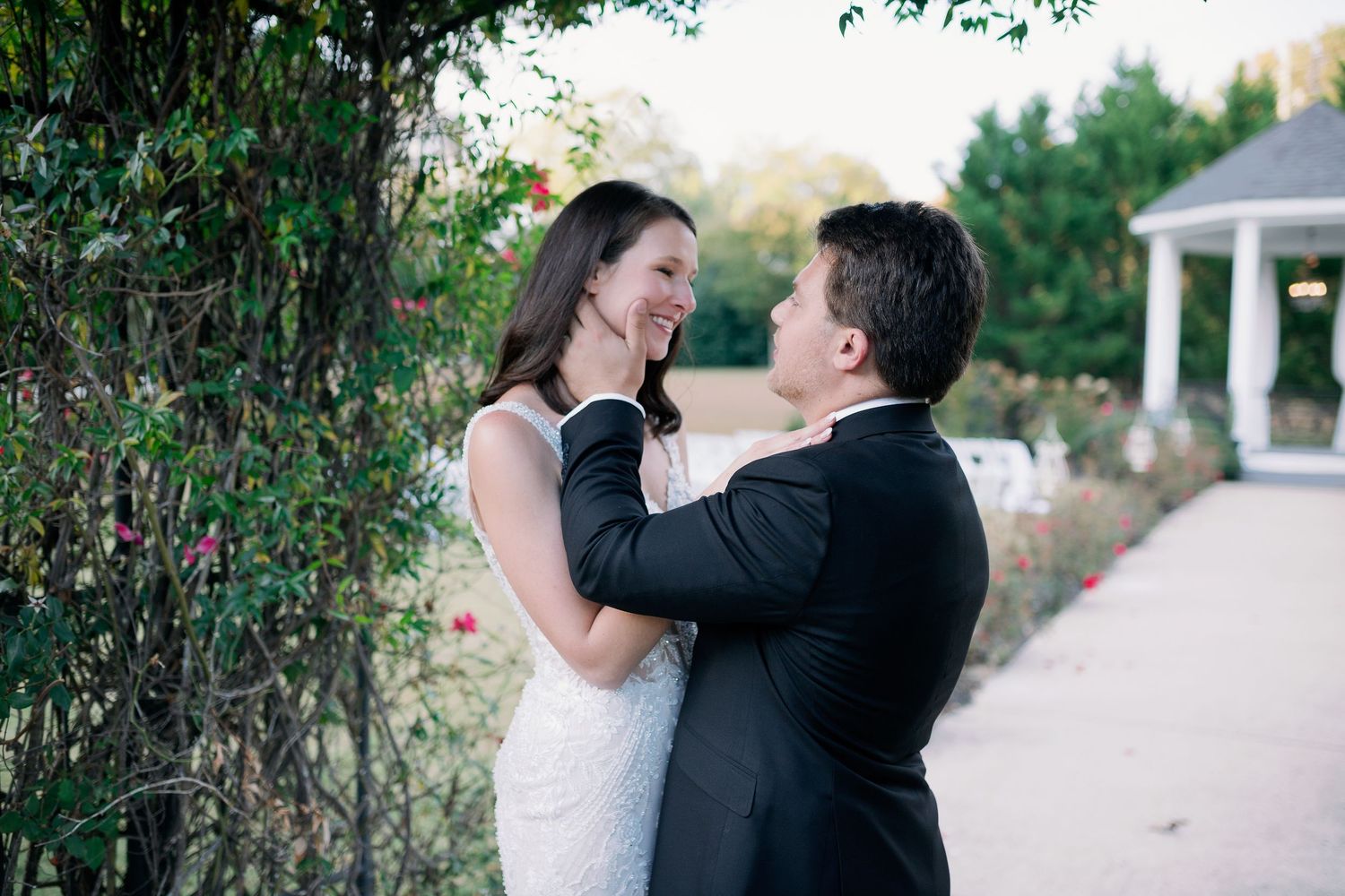 groom holds bride cheek as they look at each other