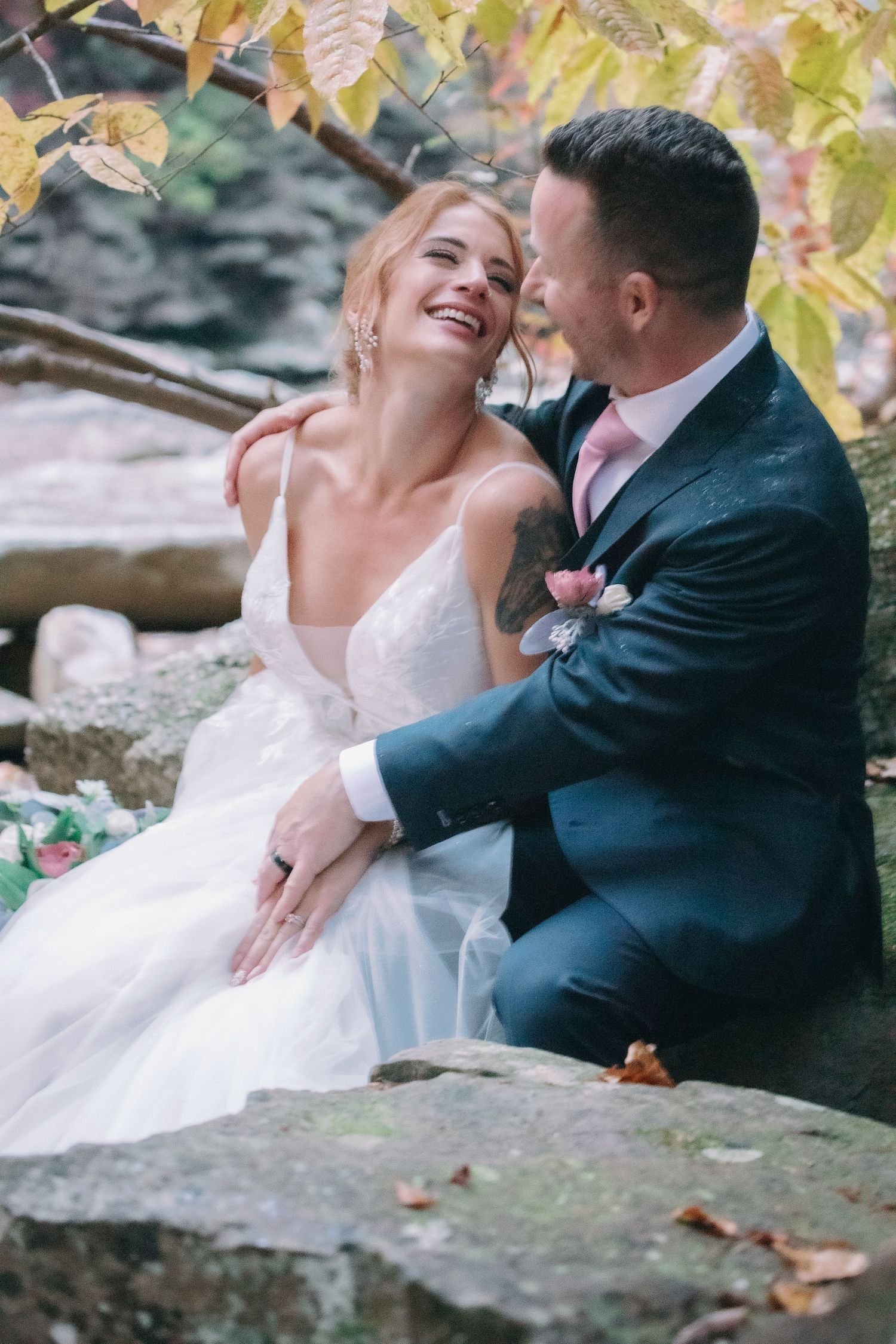 couple looks at each other under yellow leaves